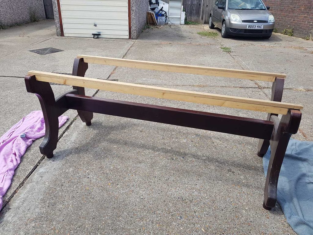 A photo of the table's "H" legs with 2 mahogony-topped supporting rails